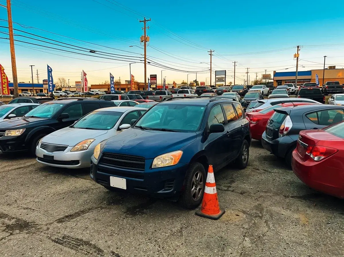 The same SUV lot photo after Ideogram Edit, under a clear blue late afternoon sky