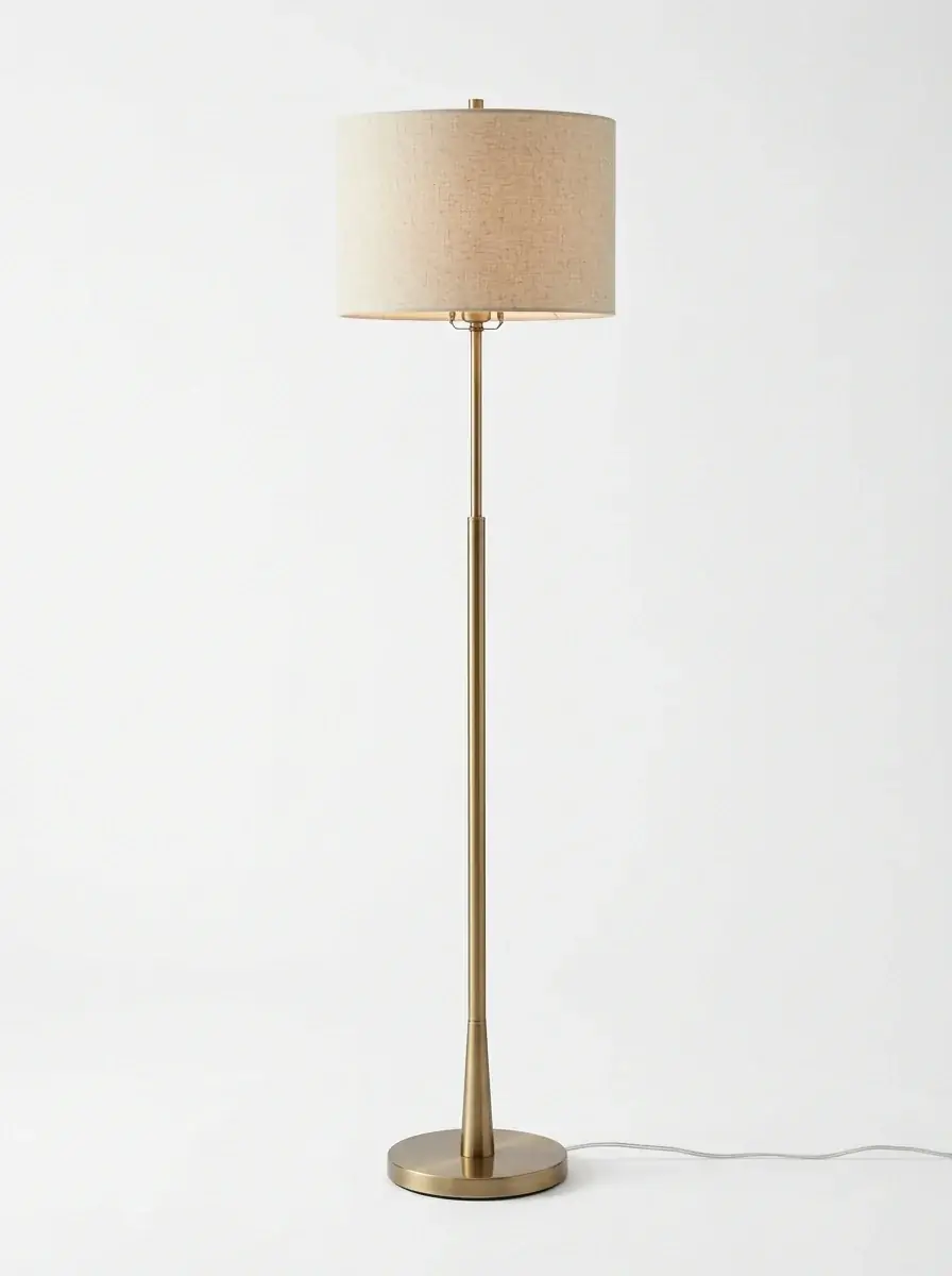 A generated catalog photo of a brass floor lamp with a linen drum shade on a white background