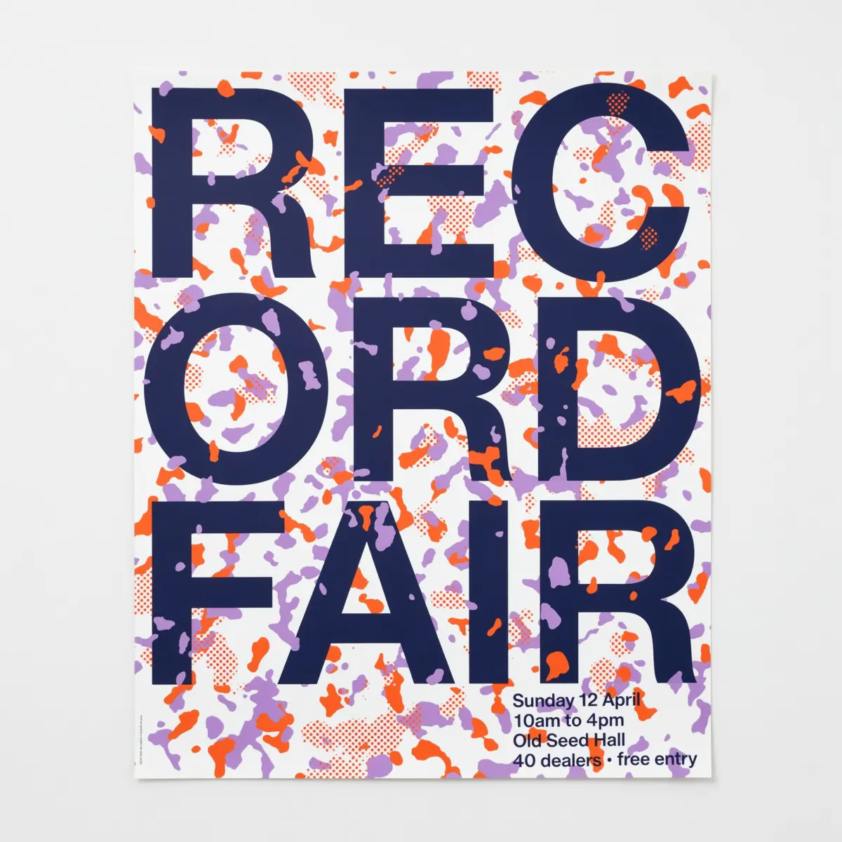 Ideogram 4.5: REC, ORD and FAIR in navy over scattered orange and lavender blots on white paper, the sheet shown against a pale grey wall with a margin around it