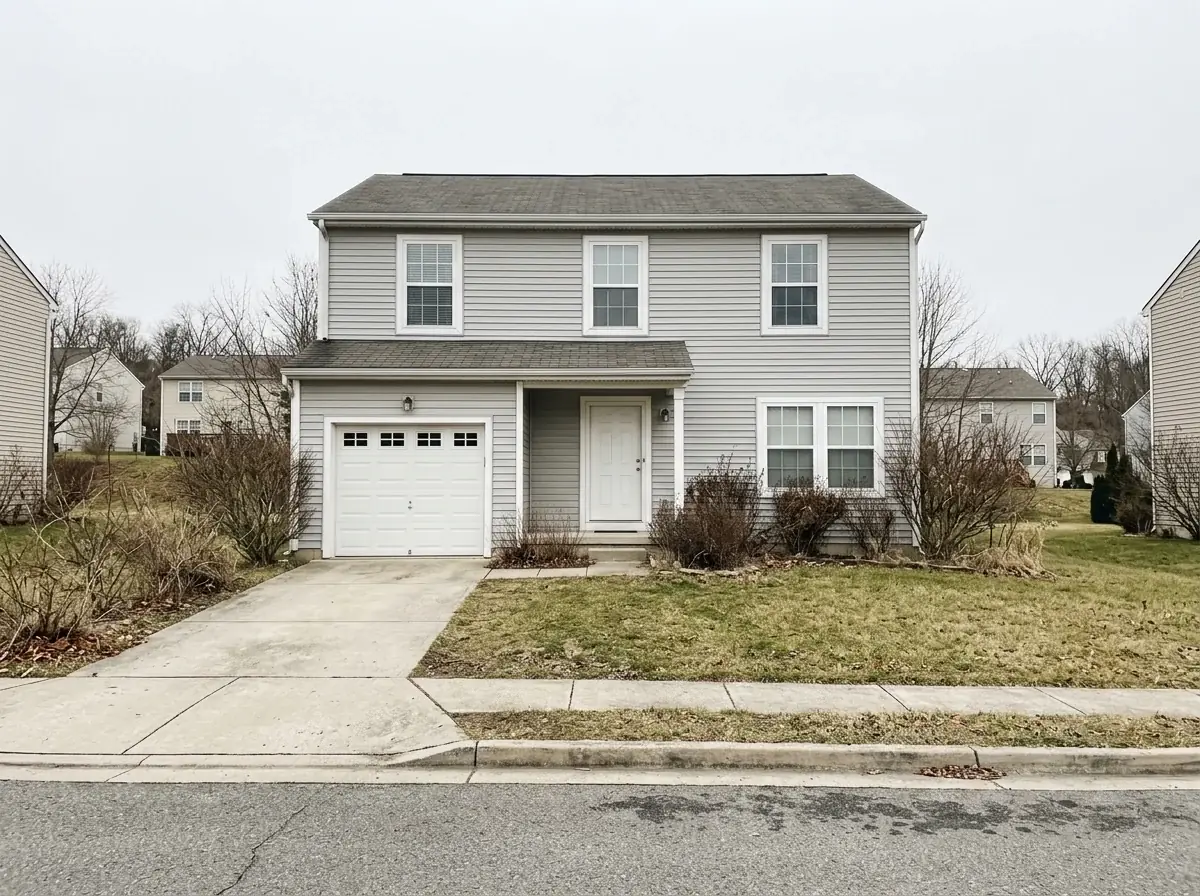 A generated daytime photo of a two-story house with grey siding, a single garage and bare shrubs under a flat white overcast sky